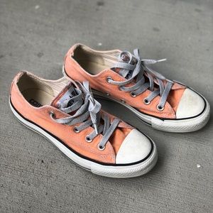 Orange low top Converse with a worn-in look